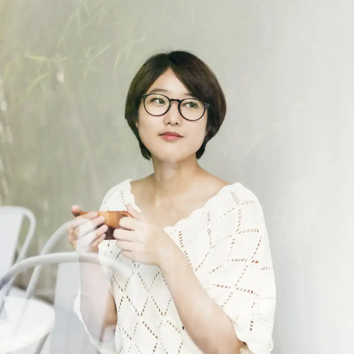 Relaxed woman with glasses enjoying tea at Zen Nail Lounge Upland.