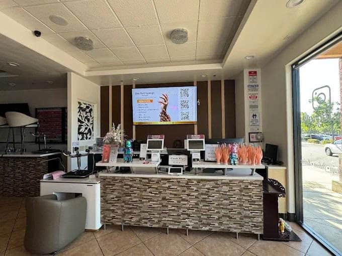 Elegant nail salon reception area with modern decor and digital check-in stations.